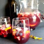 A pitcher and two glasses filled with classic Spanish Red wine Sangria drink.