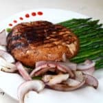 A dinner serving with grilled portbello mushrooms, asparagus and onions.