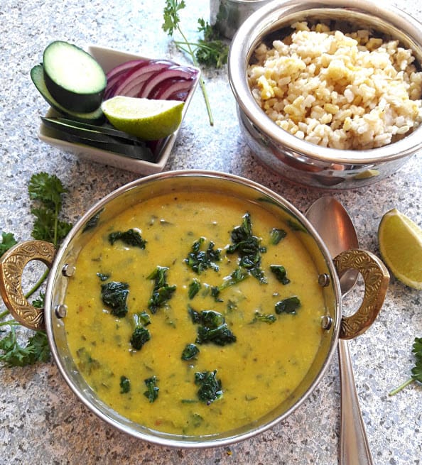 Spinach Lentil Curry with onions, lime wedges and rice