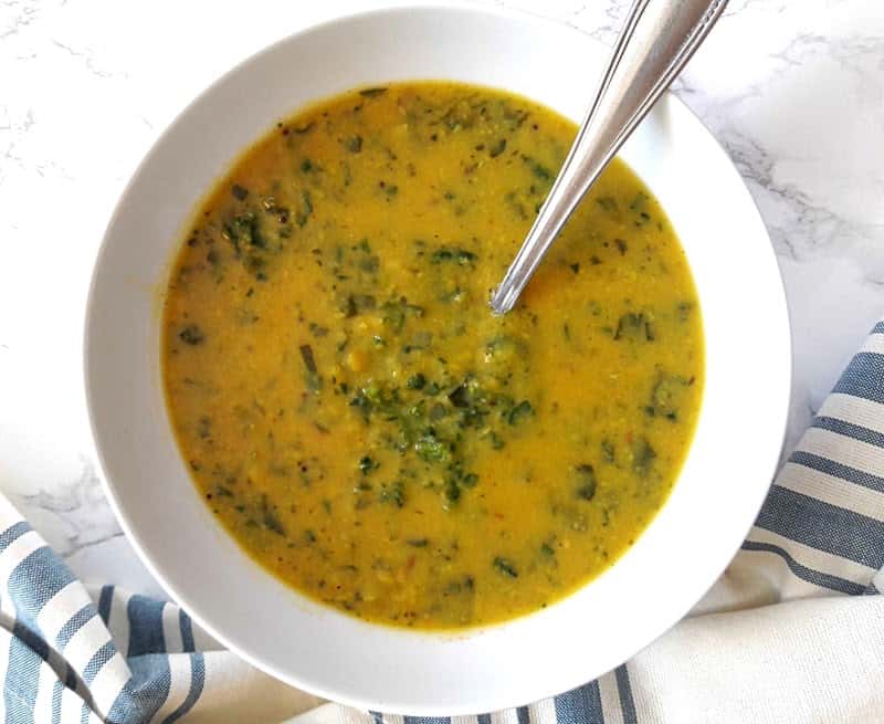 Dal Palak with a spoon in a white bowl