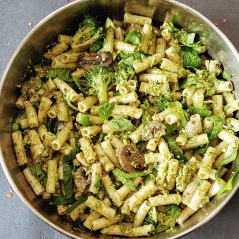 A skillet full of pesto coated vegetables and pasta to make this Penne Pesto Primavera recipe at home.