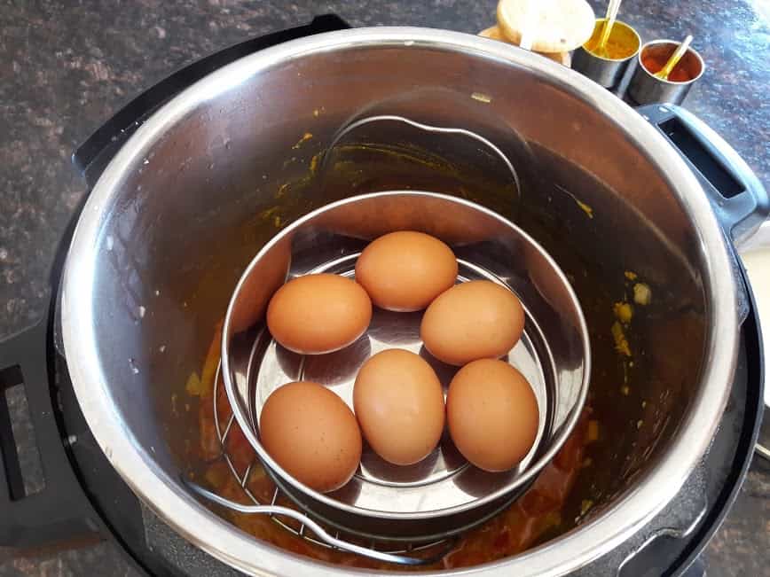 Pot in pot cooking showing top tier of stack of cooked eggs in Instant pot.