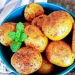 A bowl filled with Bombay Potatoes. Bombay Potatoes, also known as Bombay Aloo, are a popular Indian dish originating from the streets of Mumbai, formerly known as Bombay. It's a flavorful and aromatic preparation of potatoes cooked with a variety of spices, creating a delightful dish that's both comforting and satisfying.