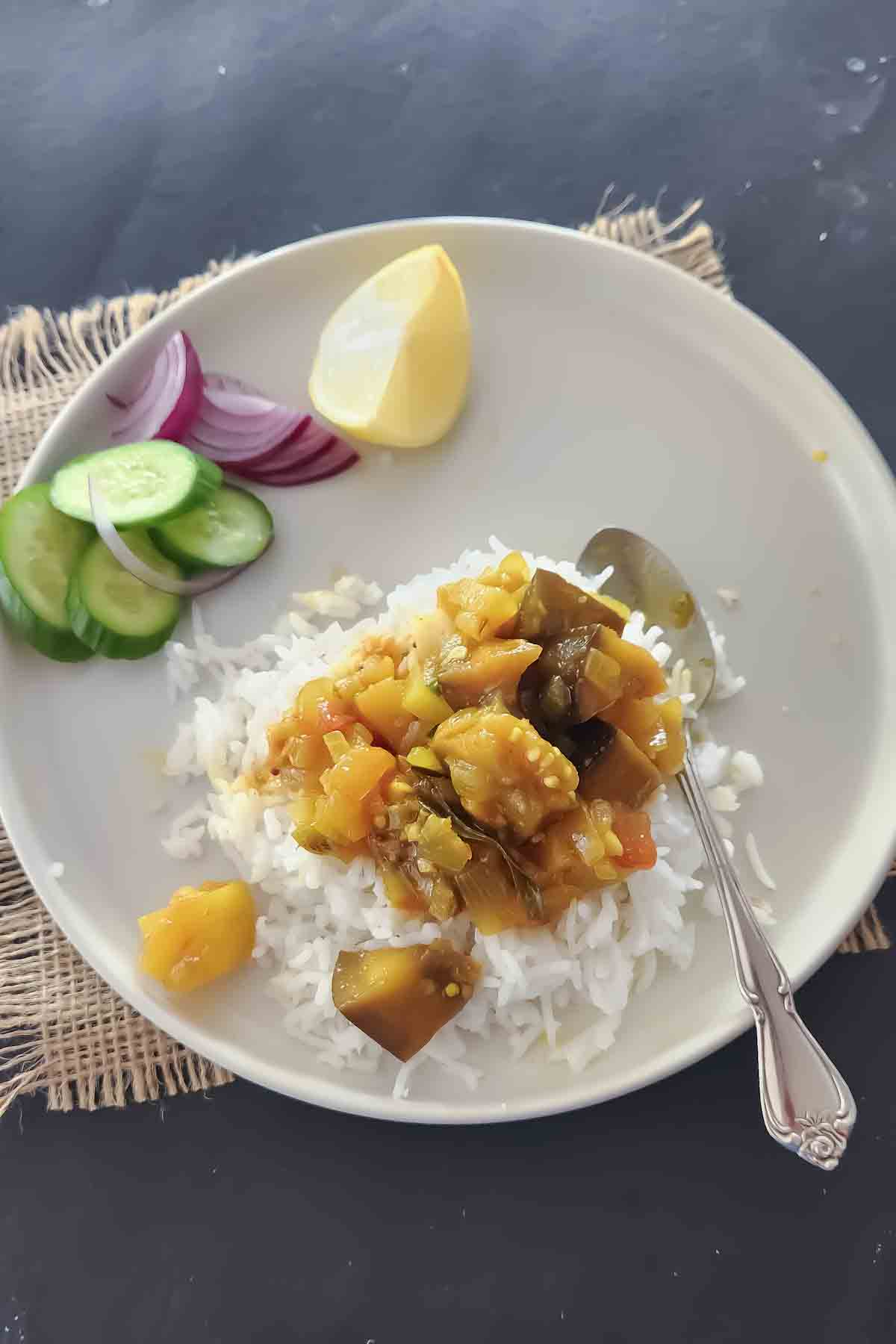 Eggplant curry served over rice and side salad served for vegan dinner.