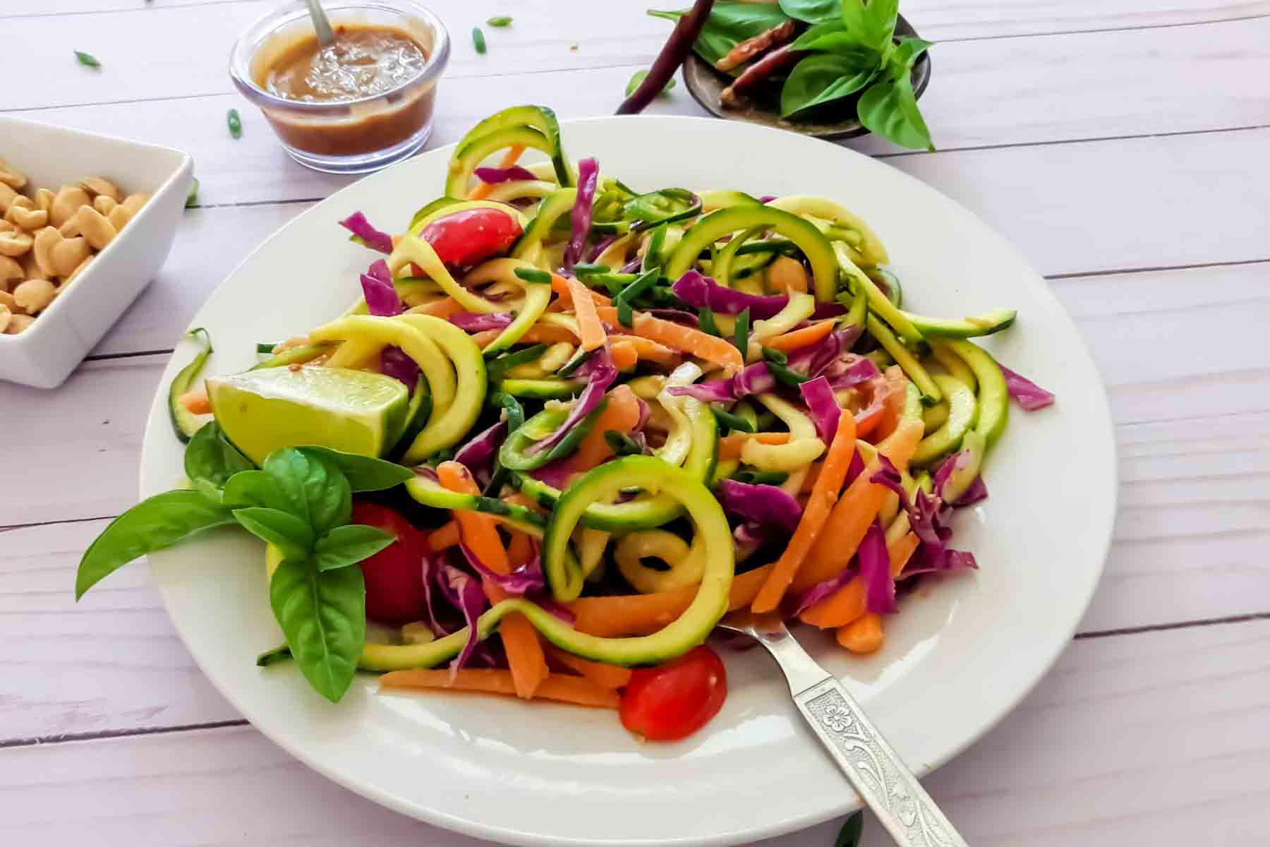 Spiralized zucchini noodles served with spicy peanut sauce.