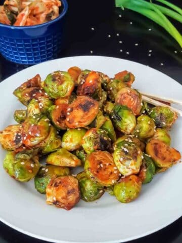 Easy gochujang Brussels sprouts side dish with sesame seeds.