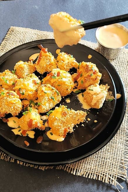 A chop stick holding a cauliflower nugget