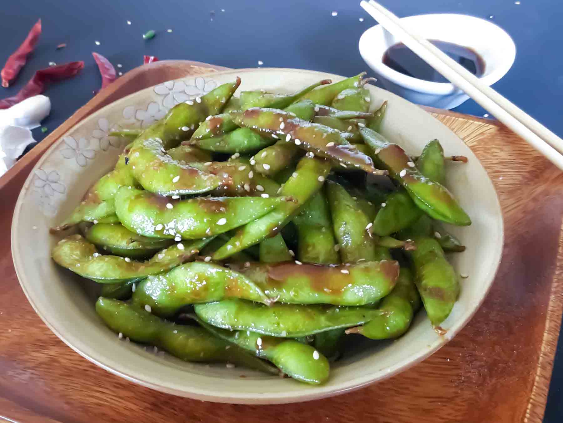 A plate full of chili garlic edamame served as an appetizer.