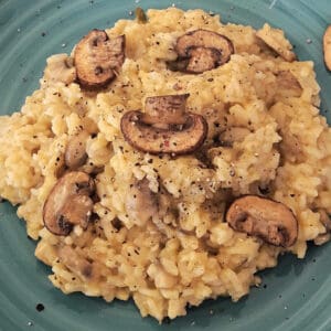Homemade vegan Mushroom Risotto with creamy texture served with sautéed mushrooms on top.