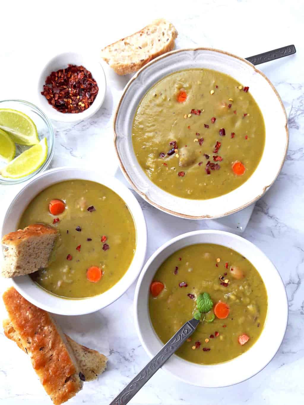 over head image of split pea soup dinner served with bread.