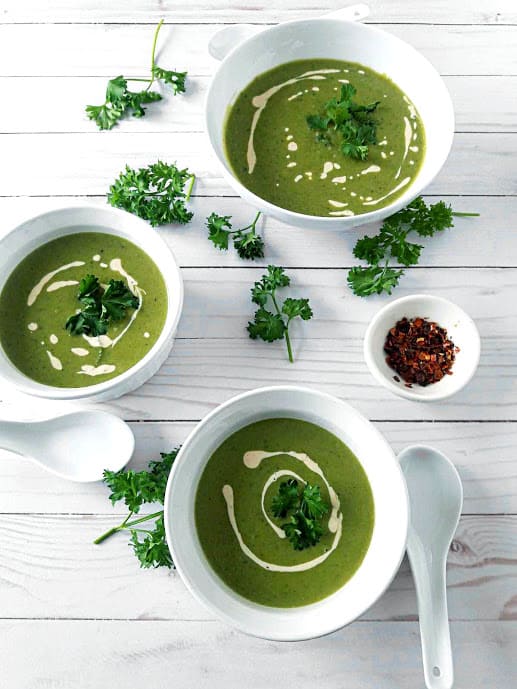 Green Pea and Mint Soup in 3 serving bowls with decorations