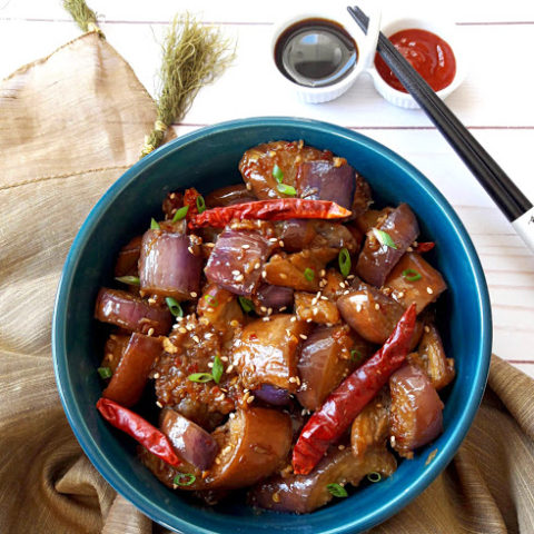 Chinese Spicy Eggplant in blue serving bowl with chop sticks on the side