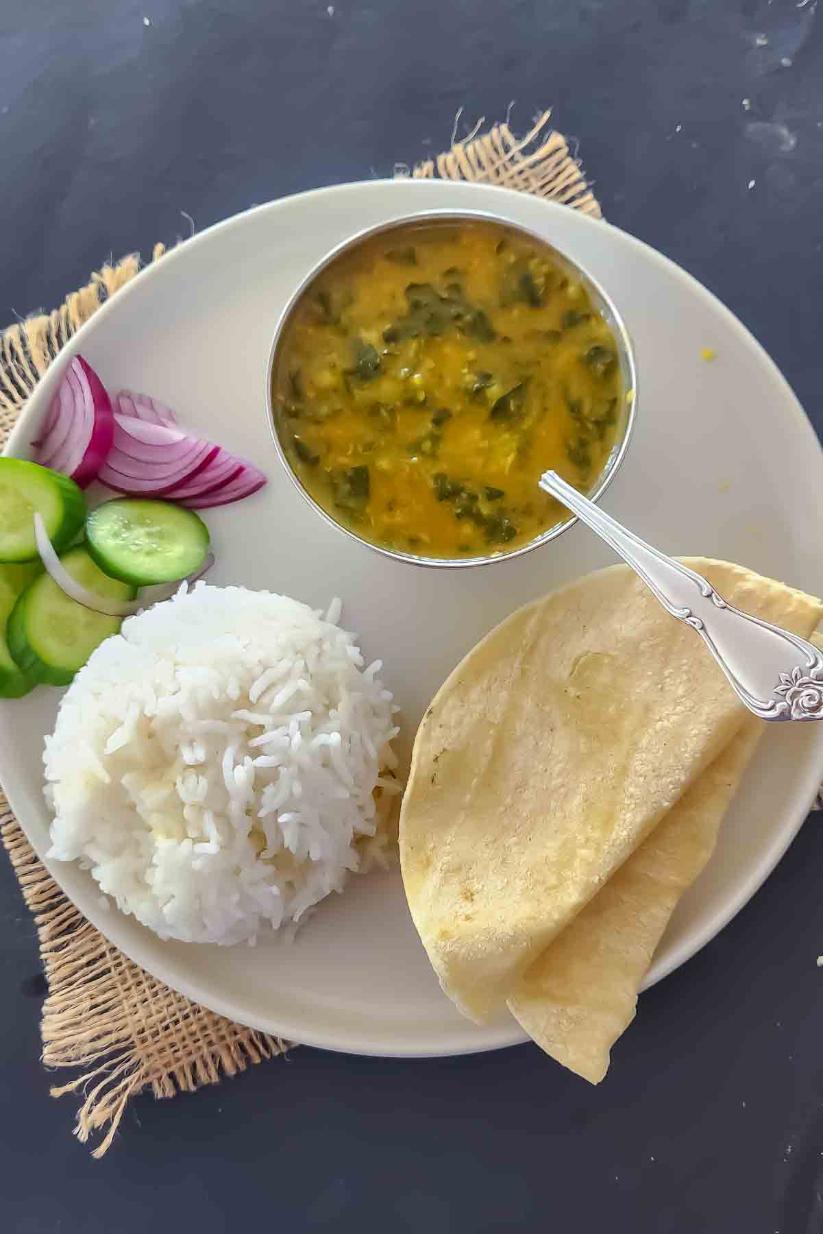 Easy Spinach Dal recipe served in a bowl with rice and roti for an Indian dinner.