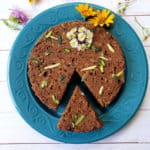 Instant Pot Zucchini Bread with cut slice served in blue plate and decorated with summer time wild flowers