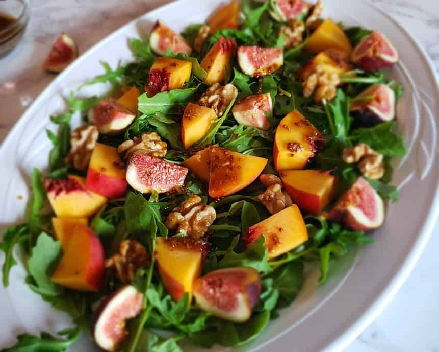 Close up view of tossed up fig arugula salad