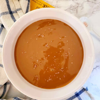 Overhead shot of Instant pot caramel cream served with sea salt crystals on marble countertop.