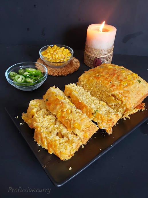 Southern style cornbread sliced and served in beautiful setting with candle lit in the background.