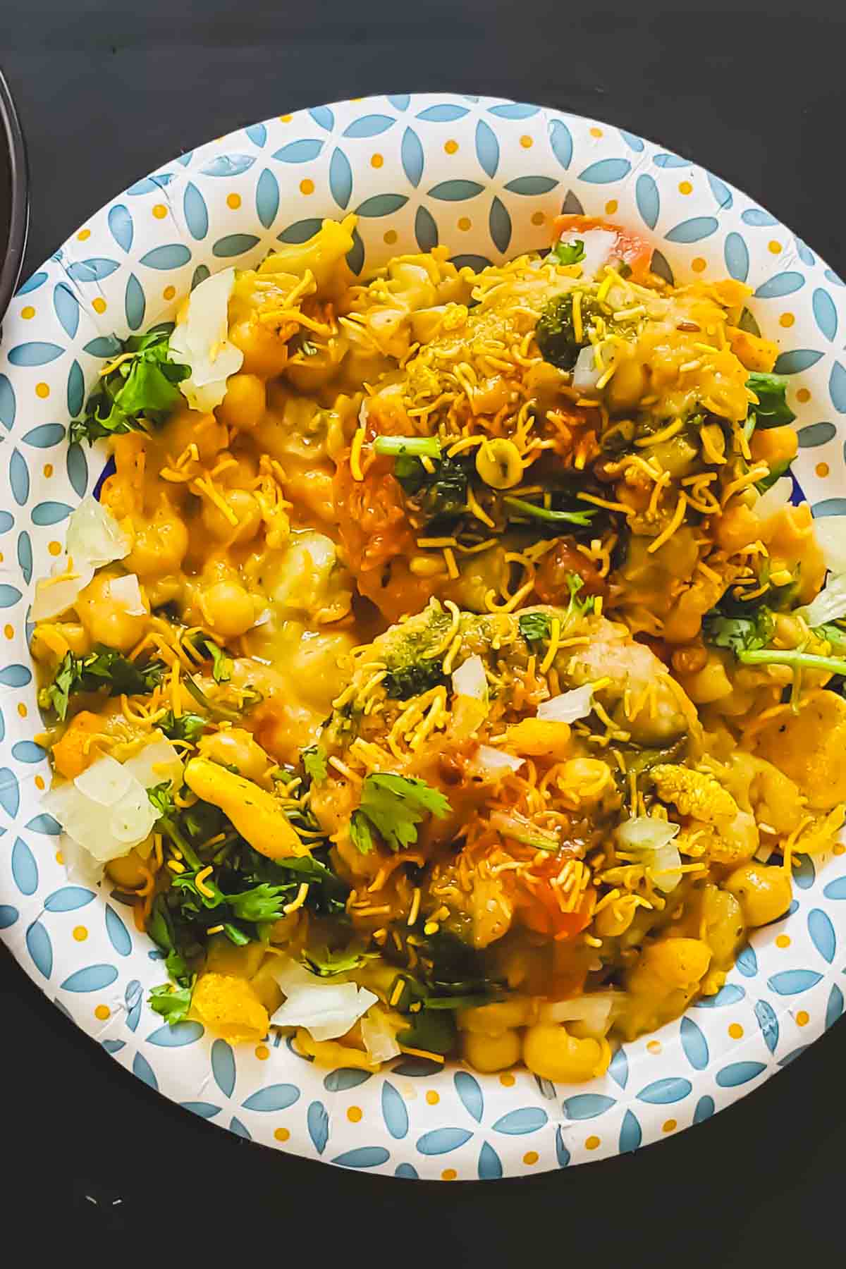 Close-up of crispy aloo tikki with ragda curry.