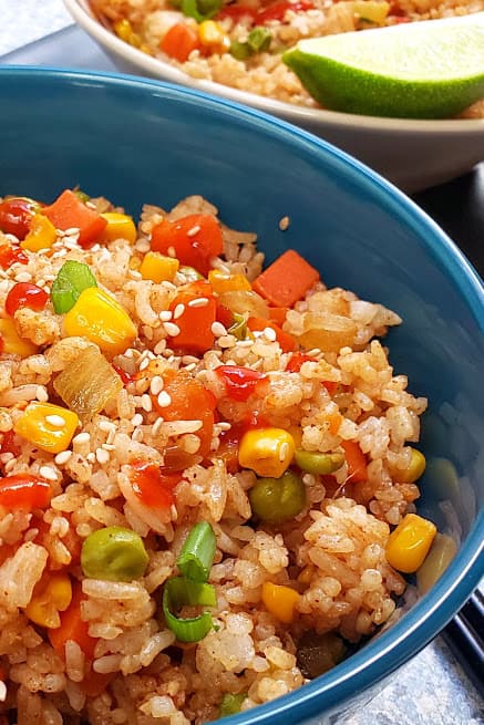 Close up image showing textures and layers of garnishes of Hibachi Vegetable Fried Rice