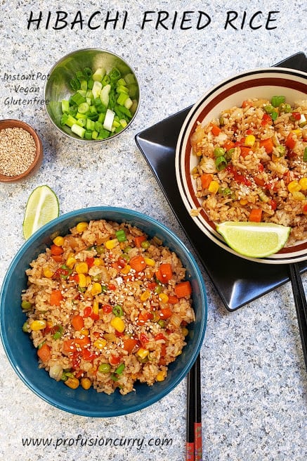 Hibachi fried rice served in two bowls with chopsticks and garnishes.