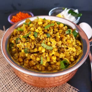 Moong Sprouts Curry cooked perfectly in pressure cooker. Showing close up image of the curry served in ethnic copper container.