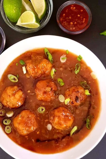 Delicious vegetable manchurian served in white bowl with green onion garnish. This delicious Profusioncurry recipe is popular Indo Chinese street food.