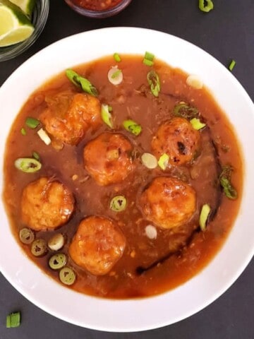 Veggie filled dumplings tossed in delicious manchurian sauce. This popular Indo Chinese street food recipe is tweaked to make low calorie and figure friendly.