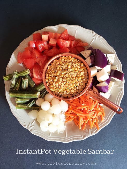 ingredients needed to make Indian sambar recipe displayed on the diner plate. This vegetable dal praparation uses variety of different spices and flavors.