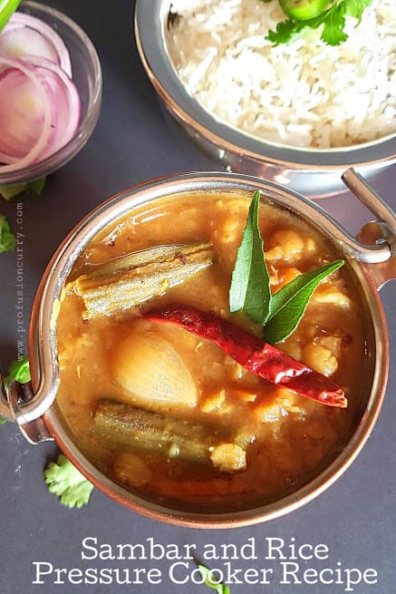 vegetable Sambar with rice served in copper containers served with red onions salad.