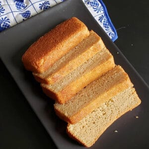 Beautifully sliced rich hot milk cake served on black serving platter.