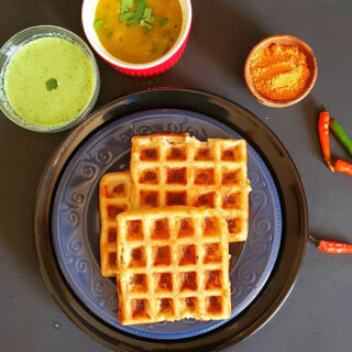 Stack of dosa waffles served with vegetable sambar, cilantro chutney and dry chutney. This savory waffle recipe is glutenfree and vegan.