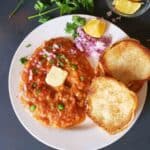 Instant Pot Pav Bhaji served with buttered pav, chopped onions, cilantro, and lemon wedges for delicious Indian Street Food Dinner.