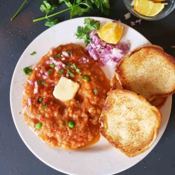 Instant Pot Pav Bhaji served with buttered pav, chopped onions, cilantro, and lemon wedges for delicious Indian Street Food Dinner.