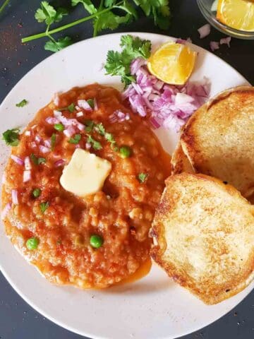 Instant Pot Pav Bhaji served with buttered pav, chopped onions, cilantro, and lemon wedges for delicious Indian Street Food Dinner.