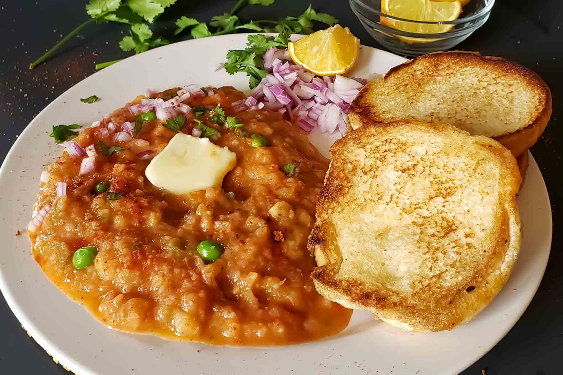 Healthy Instant Pot Pav Bhaji in a bowl topped with butter and fresh cilantro.