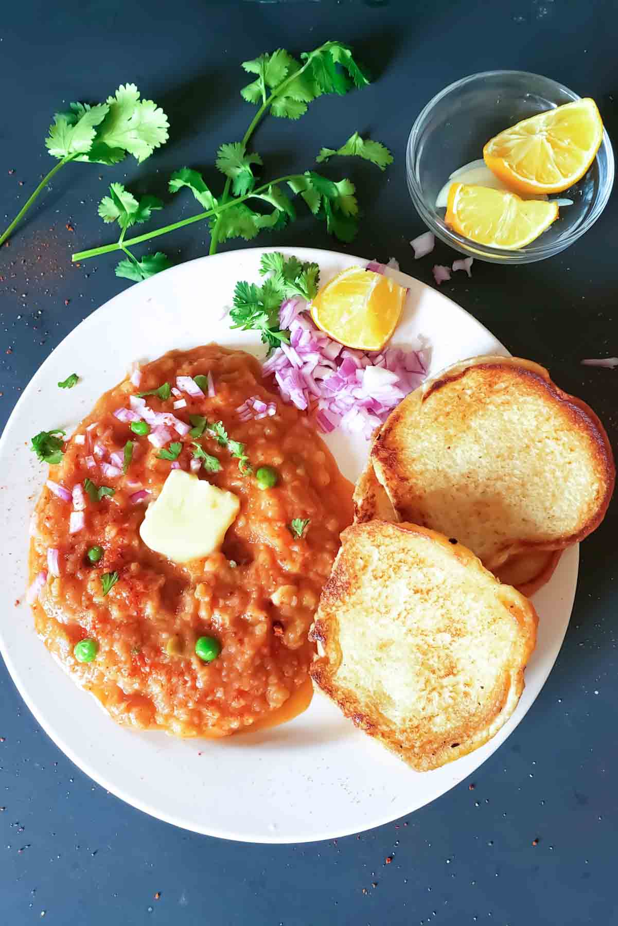 Easy Indian street food recipe for Pav Bhaji made with potatoes, cauliflower, peas, and tomatoes.