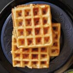 Savory Multigrain dosa waffles served on blue and black dinner plate.