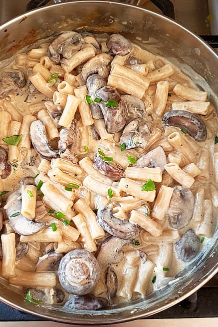 A pan full of creamy mushroom pasta ready to be served.