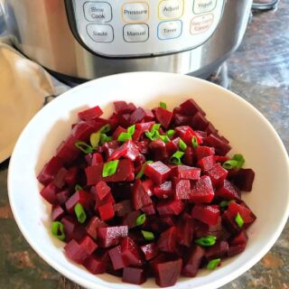 Instant Pot Steamed Beets are cooked and roughly chopped and garnished with chives.