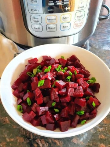 Instant Pot Steamed Beets are cooked and roughly chopped and garnished with chives.