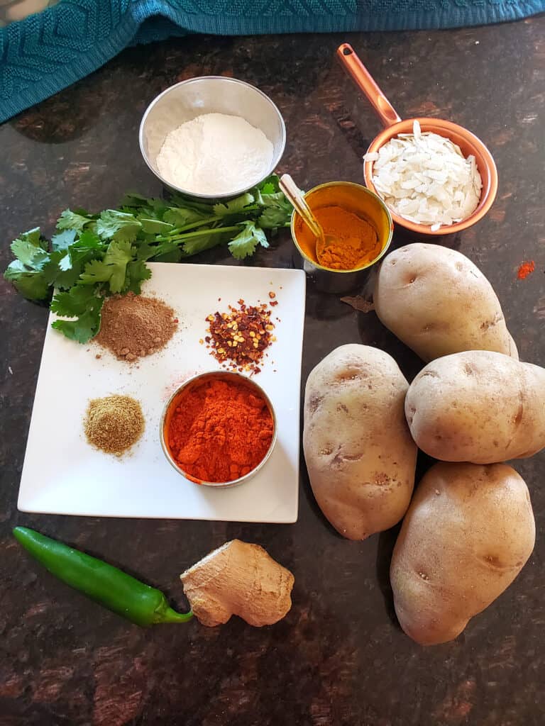 ingredient needed to make masala potato patties displayed on black countertop.