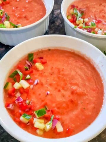 Healthy vegan gazpacho recipe blended with ripe tomatoes and colorful summer vegetables.