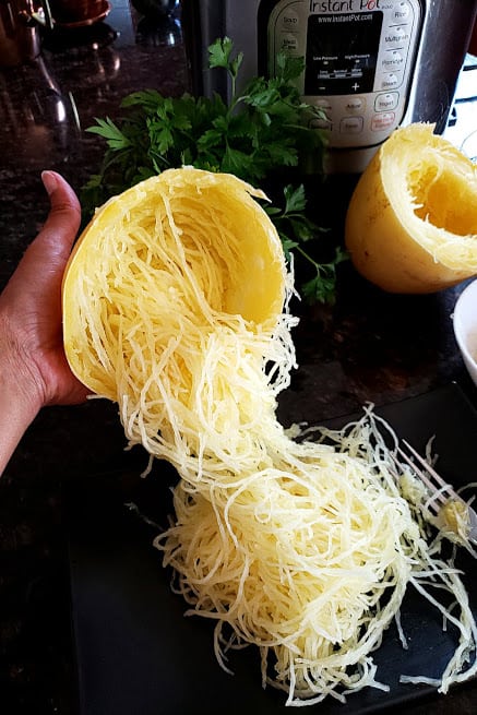Noodles forking out of half of spaghetti squash 