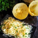 A dinner plate full of seasoned spaghetti squash noodles cooked in electric pressure cooker Instantpot.