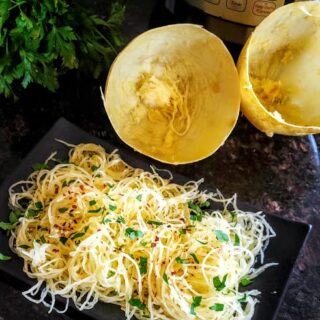 A dinner plate full of seasoned spaghetti squash noodles cooked in electric pressure cooker Instantpot.