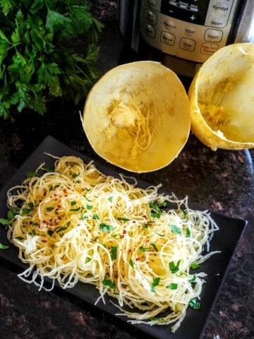 A dinner plate full of seasoned spaghetti squash noodles cooked in electric pressure cooker Instantpot.