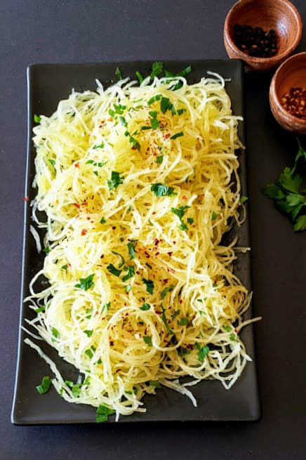 A dinner plate with heaps of squash spaghetti noodles.