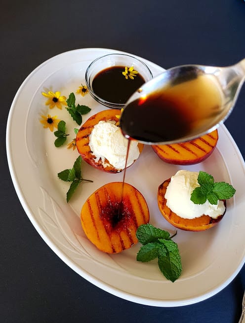 A pour shot of maple balsamic glaze over grilled peach.