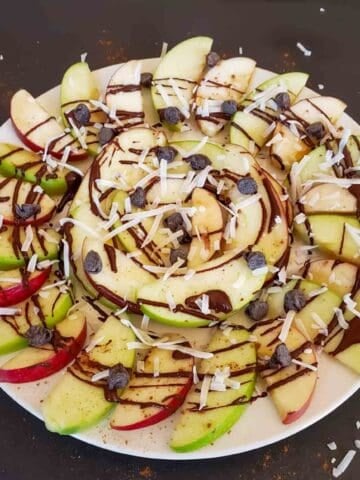 Apple nachos with peanut butter, chocolate, coconut flakes and chocolate chips for a healthy, quick, vegan and gluten-free snack/dessert.