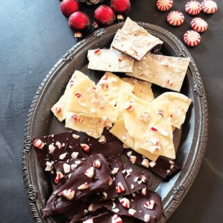 An assortment of dark, white and layered chocolate bark along with Christmas decorations.
